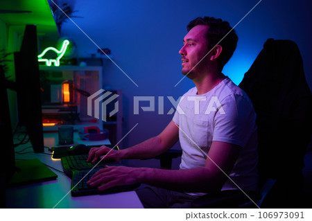 Player looking at his computer screen, contemplating his next move in an online video game. Player looking at his computer screen, contemplating his next move in an online video game. 106973091