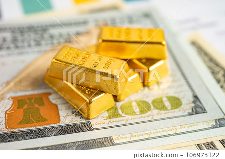 Gold bar on US dollar banknotes money and graph, economy finance exchange trade investment concept. Gold bar on US dollar banknotes money and graph, economy finance exchange trade investment concept. 106973122