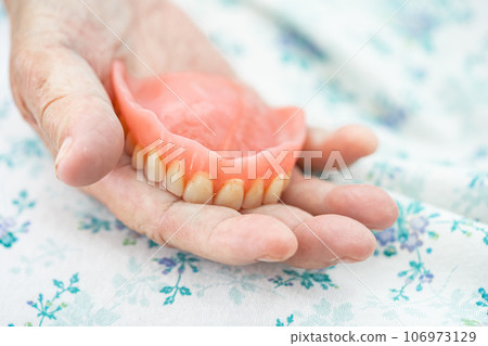 Asian elderly woman patient holding to use denture, healthy strong medical concept. Asian elderly woman patient holding to use denture, healthy strong medical concept. 106973129