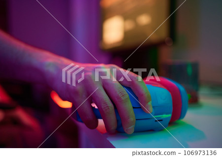 A young guy gets a phone call during an online video game, he takes off his headphones and goes to talk. A young guy gets a phone call during an online video game, he takes off his headphones and goes to talk. 106973136