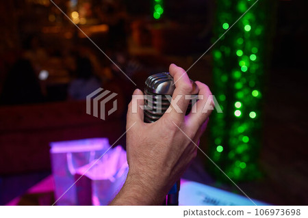 Retro Microphones on front stage in pub bar or restaurant. Classic sing a song in evening and night show concert light bokeh background. Retro Microphones on front stage in pub bar or restaurant. Classic sing a song in evening and night show concert light bokeh background. 106973698