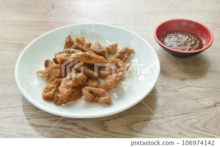 crispy fried pork innards with flour on plate dipping with spicy tamarind sauce crispy fried pork innards with flour on plate dipping with spicy tamarind sauce 106974142