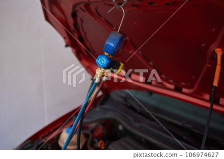 monitor tool on car engine ready to check and fixed car air conditioner system in car garage. monitor tool on car engine ready to check and fixed car air conditioner system in car garage. 106974627