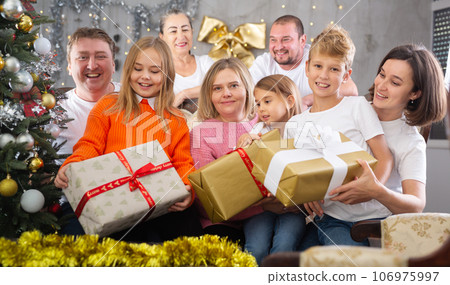 Family with children holding gifts in christmas interior Family with children holding gifts in christmas interior 106975997