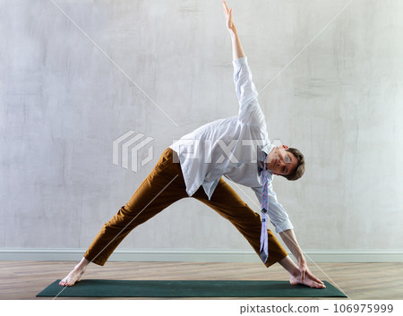 Young guy office worker doing yoga in studio Young guy office worker doing yoga in studio 106975999