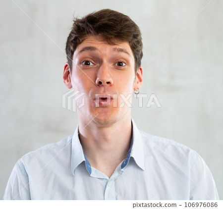 Portrait of young surprised guy in studio 106976086
