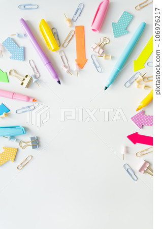 Top view of bright school supplies with blank paper for layout or text. Vertical photo. Top view of bright school supplies with blank paper for layout or text. Vertical photo. 106976217