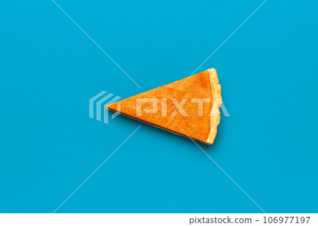 Pumpkin pie slice isolated on a blue background Pumpkin pie slice isolated on a blue background 106977197
