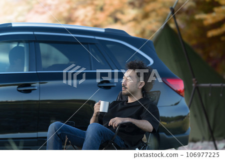 A man relaxing at a campsite, image of auto camping and solo camping, autumn A man relaxing at a campsite, image of auto camping and solo camping, autumn 106977225