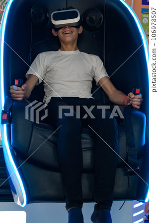 A guy is sitting on a ride with vr glasses, 106978507