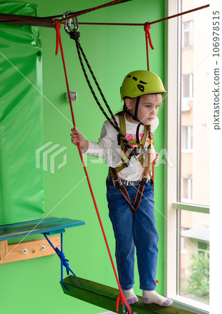 Children's cableway in the playroom, little girl passes the cableway. 106978515