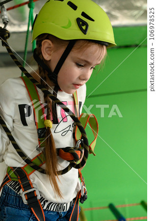 A little girl walks on a cableway, a playroom with a cable car. A little girl walks on a cableway, a playroom with a cable car. 106978525