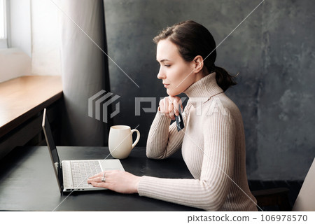 Young Woman Engaging in Seamless Online Shopping Experience with Laptop and Credit Card: E-commerce 106978570