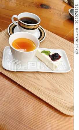 Cake set for relaxing in a coffee shop with sunlight filtering through the trees Cake set for relaxing in a coffee shop with sunlight filtering through the trees 106979598