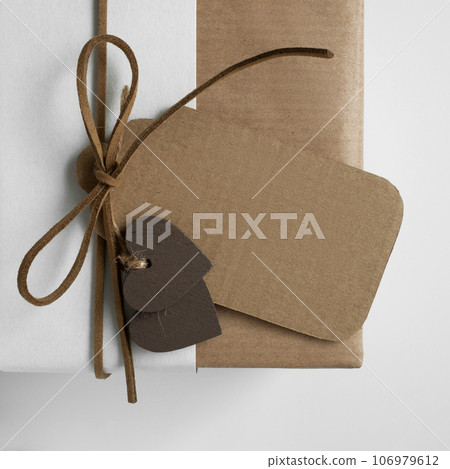 Brown craft gift tag on the gift box. Space for your text. Brown craft gift tag on the gift box. Space for your text. 106979612