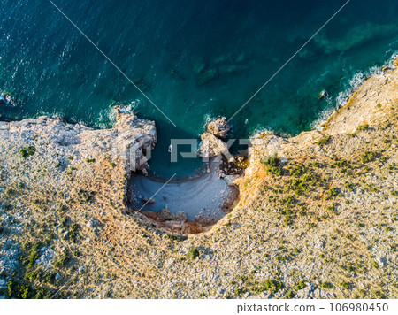 Top view of a beautiful sea harbor. Lagoon with dark blue water. Waves near rocky coast and boat Top view of a beautiful sea harbor. Lagoon with dark blue water. Waves near rocky coast and boat 106980450