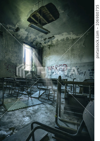 old  and vandalised interior of a school classroom 106980735