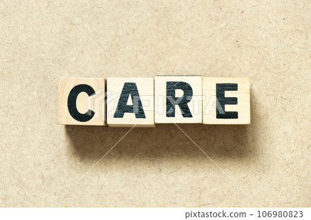 Alphabet letter block in word care on wood background Alphabet letter block in word care on wood background 106980823