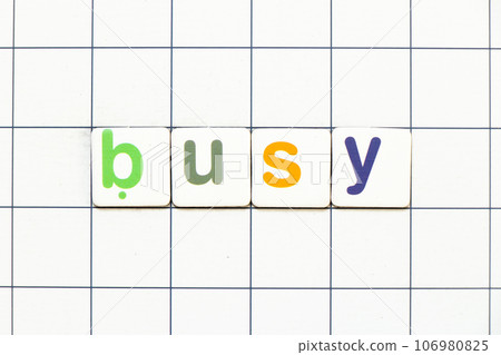 Colorful tile letter in word busy on white grid background 106980825