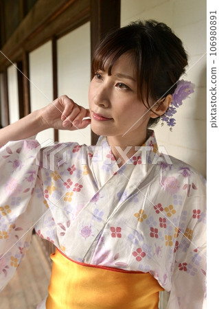 一位穿著浴衣的年輕女子在一座古老民居的走廊裡 106980891