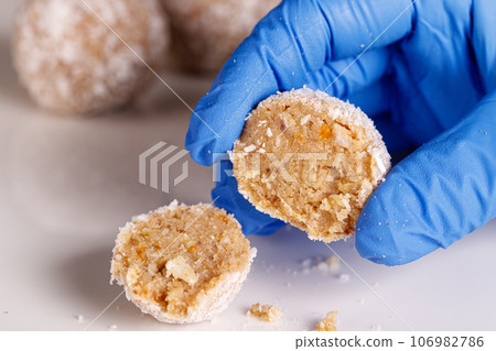 Beautiful sweets with coconut on a white plate on a black background 106982786