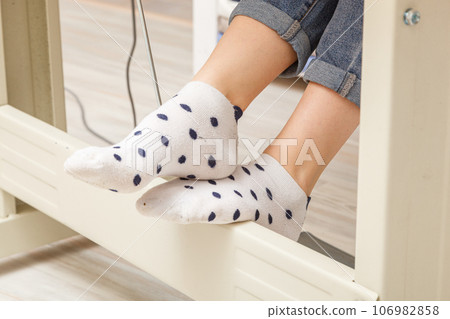 Female feet on the pedal of a sewing machine, motor 106982858