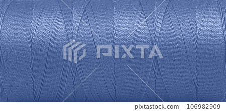 Texture of threads in a spool of blue color on a white background 106982909