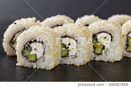 Sushi with salmon on a white plate with wasabi, ginger, soy, chopsticks on a black background 106982989