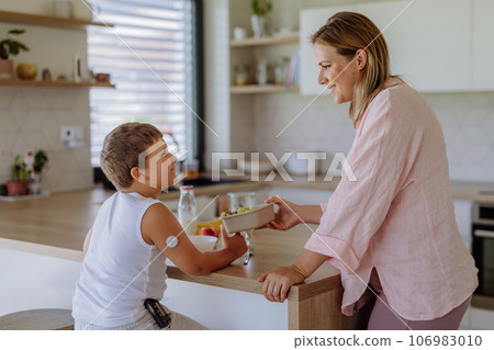Diabetic boy with a continuous glucose monitor is careful with his diet. Diabetic boy with a continuous glucose monitor is careful with his diet. 106983010