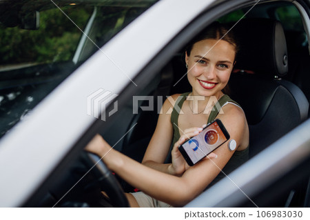 Woman with diabetes checking her blood glucose level before driving a car. 106983030