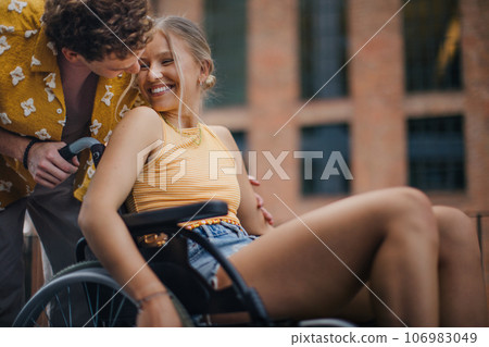 Beautiful gen Z girl in a wheelchair with her boyfriend. Beautiful gen Z girl in a wheelchair with her boyfriend. 106983049