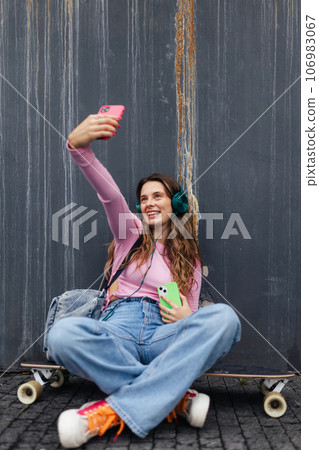 Portrait of generation z girl student sitting outdoors in the city and taking selfie. Portrait of generation z girl student sitting outdoors in the city and taking selfie. 106983067