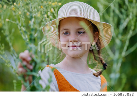 Portrait of a cute little girl in an autumn garden. 106983088