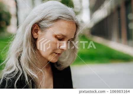 Portrait of beautiful woman in middle age with gray hair. Portrait of beautiful woman in middle age with gray hair. 106983164