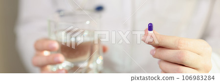 Woman doctor shows single pill in her hand close-up. Woman doctor shows single pill in her hand close-up. 106983284