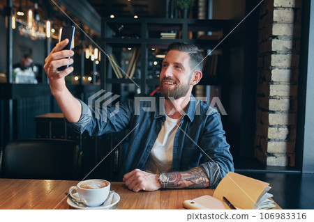 Man looking into the camera while making a selfie Man looking into the camera while making a selfie 106983316