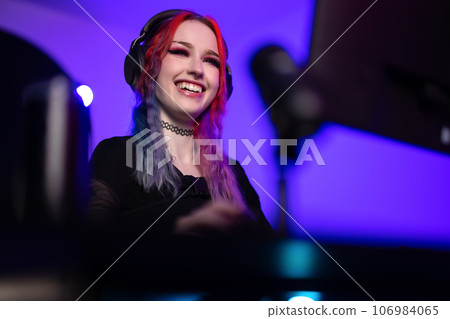 Beautiful and natural smiling esport gamer girl live streaming and plays online video game on computer Beautiful and natural smiling esport gamer girl live streaming and plays online video game on computer 106984065