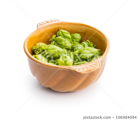 Green hops crop in bowl isolated on white background. Green hops crop in bowl isolated on white background. 106984094