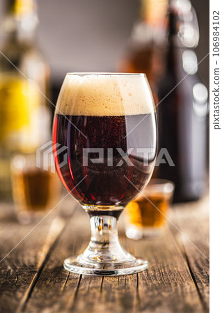 Dark beer in beer glass on wooden table. 106984102