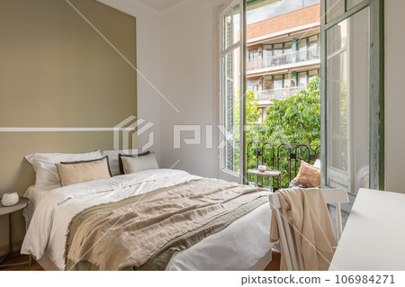 Chic double bed against the backdrop of an open window overlooking the sunny summer weather. Honeymoon hotel room concept. Copyspace 106984271