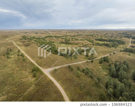 landscape of Nebraska Sandhills with road crossing, early morning aerial view at Nebraska National Forest landscape of Nebraska Sandhills with road crossing, early morning aerial view at Nebraska National Forest 106984323