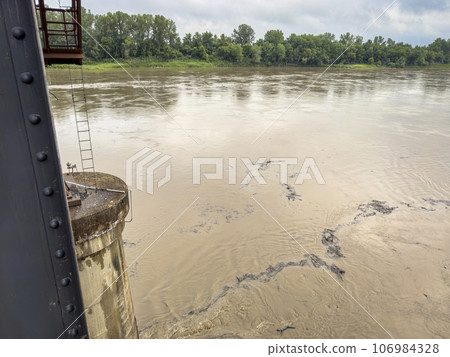 debris floating on the rising Missouri River seen from an old railroad bridge in Boonville, MO debris floating on the rising Missouri River seen from an old railroad bridge in Boonville, MO 106984328