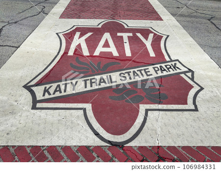 Katy Trail State Park sign on the street crossing in Boonville, Missouri. Katy trail is the nation's longest rails-to-trails project, 237 mile bike trail, stretching from the Machens to Clinton. Katy Trail State Park sign on the street crossing in Boonville, Missouri. Katy trail is the nation's longest rails-to-trails project, 237 mile bike trail, stretching from the Machens to Clinton. 106984331
