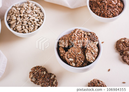 Homemade crispbread made from flax and sunflower seeds in a bowl on the table 106984355