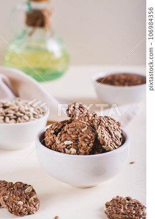 Crispy baked bread from flax and sunflower seeds in a bowl on the table vertical view Crispy baked bread from flax and sunflower seeds in a bowl on the table vertical view 106984356