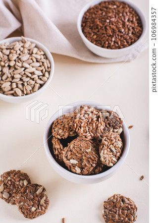 Homemade crispbread made from flax and sunflower seeds in a bowl on the table vertical view 106984357