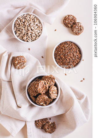 Homemade crispbread made from flax and sunflower seeds in a bowl on the table top and vertical view Homemade crispbread made from flax and sunflower seeds in a bowl on the table top and vertical view 106984360
