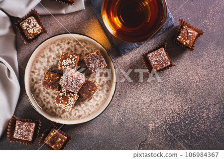 Healthy candies made from figs, dates, nuts, coconut and sesame seeds on a plate top view Healthy candies made from figs, dates, nuts, coconut and sesame seeds on a plate top view 106984367