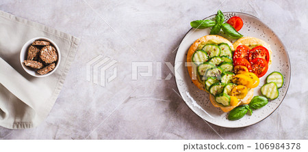 Bruschetta heart with guacomole, tomatoes and cucumber on a plate top view web banner Bruschetta heart with guacomole, tomatoes and cucumber on a plate top view web banner 106984378