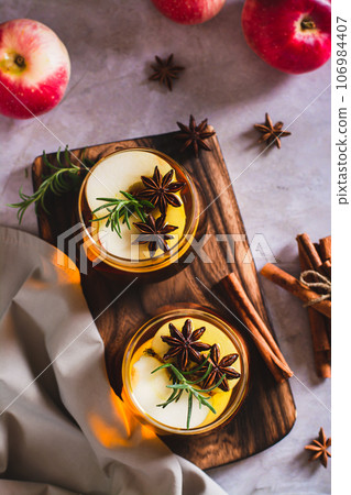 Apple margarita cocktail with cinnamon, anise and rosemary in glasses top and vertical view 106984407